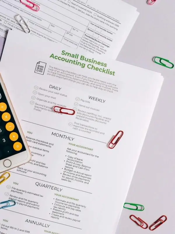 Top view of accounting essentials including smartphone, eyeglasses, and paperwork.