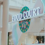 Vibrant food court signage in an indoor mall setting, inviting atmosphere.